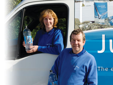 Image of the Dyers holding bottled water and with a Just Water van