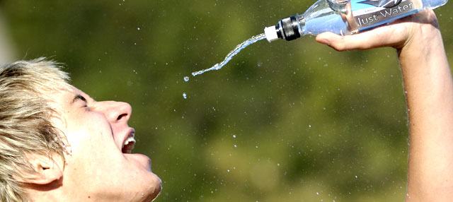 Young man drinking water from sports bottle